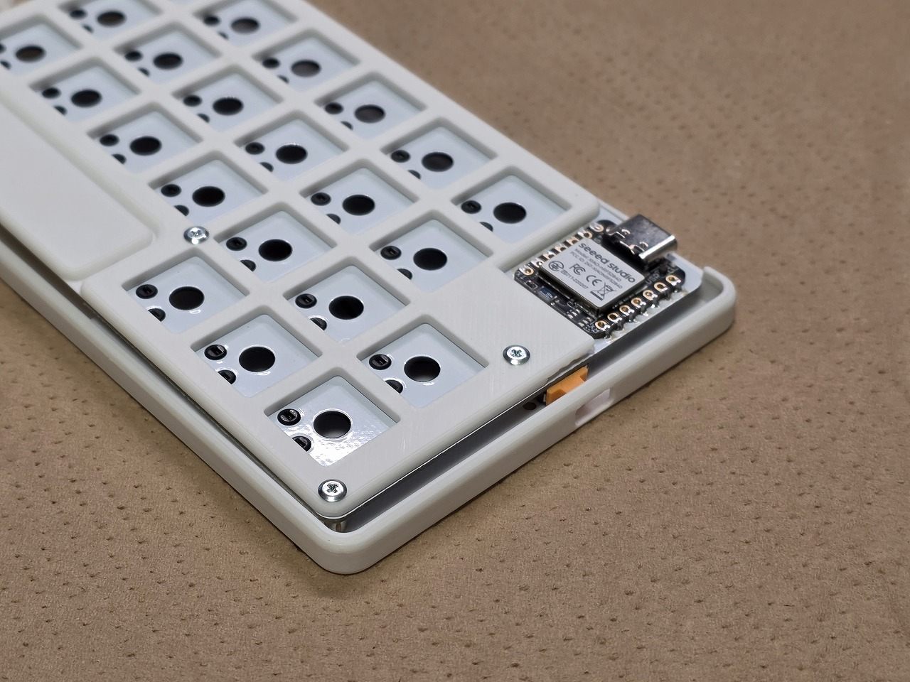 ボトムケースの穴へ電源スイッチを通している途中